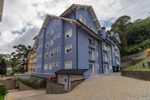 een blauw gebouw met een hondenhok ervoor bij Rosa Edifício Reservas das Orquídeas in Gramado