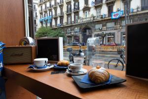 a table with croissants and cups on a table with a window at CIVICO 237 in Naples