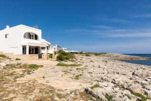 une maison blanche sur le côté d'une falaise dans l'établissement Binilaya, à Sant Lluis