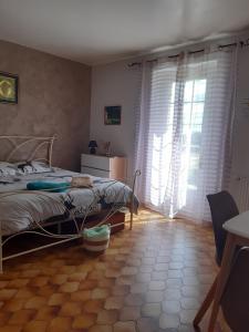 1 dormitorio con 1 cama y una ventana con cortinas en le bois du bournat, en Saint-Avit-Sénieur