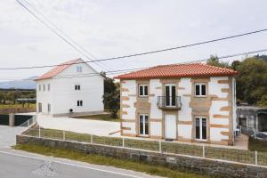 ein kleines Haus und ein weißes Gebäude auf einer Straße in der Unterkunft Casa Vilar in Ponte de Lima