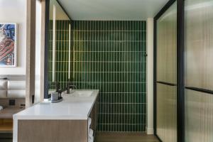 een badkamer met een wastafel en een groene betegelde muur bij W Nashville in Nashville
