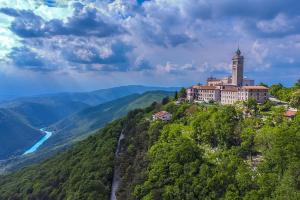 a building on top of a hill with a river at Peregrin Sveta Gora in Solkan