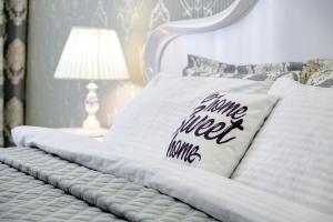 ein weißes Bett mit einem Kissen, auf dem die Worte süße Milch werden in der Unterkunft Красивая квартира в центре города с балконом in Odessa