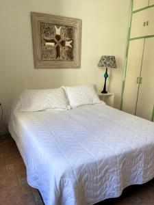 1 dormitorio con 1 cama con edredón blanco en Departamento Barrio Abasto en Buenos Aires
