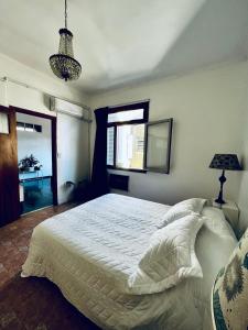 1 dormitorio con cama blanca y ventana en Departamento Barrio Abasto en Buenos Aires