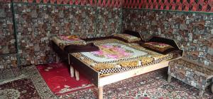 a bedroom with a bed in a room with wallpaper at POP Nafia Homestay in Bhadarwāh