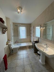 ein Badezimmer mit zwei Waschbecken, einer Badewanne und einem WC in der Unterkunft L Ancien Moulin à Huile in Tuchan