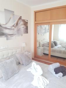 1 dormitorio con cama blanca y espejo grande en Apt a Calafell plage, en Calafell