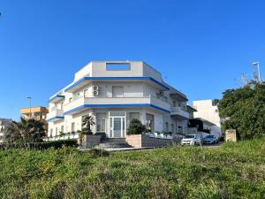 una grande casa bianca in cima a una collina di Hotel La Plancia a Otranto
