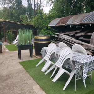a group of white chairs and tables on grass at Le Noyer: Petit chalet cosy proche de Mulhouse in Riedisheim