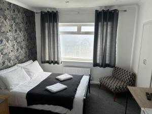 a bedroom with a bed and a chair and a window at Rock House Bed and Breakfast in Maidstone