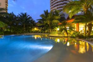 una grande piscina con palme e edifici di Ramada Hotel & Suites by Wyndham Noumea a Noumea