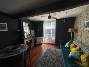 een woonkamer met een blauwe bank en een tafel bij la maison des chapeliers in Carcassonne