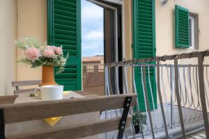 een vaas met bloemen op een tafel op een balkon bij Via Pollaiolo, 55 - Florence Charming Apartments - Comfort e Stile a 350mt dal Tram! First floor with elevator and car places on street in Florence