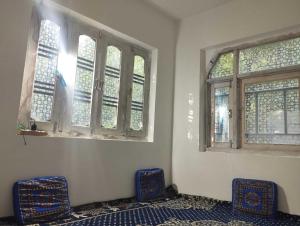 two chairs sitting in a room with windows at POP Masrat Homestay 