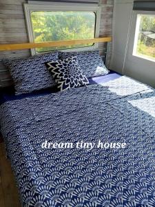 a bed with a blue and white comforter in a room at Dream Tiny House or Luxus Tent with pool in Chania Town