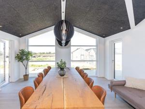 a large dining room with a wooden table and chairs at 10 person holiday home in Saltum-By Traum in Saltum