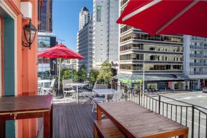 einen Balkon mit einem Tisch, Stühlen und einem Sonnenschirm in der Unterkunft The Shakespeare Hotel in Auckland