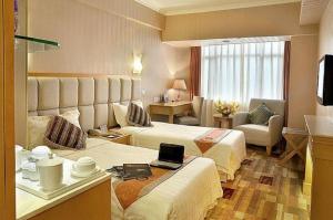 a hotel room with two beds and a television at Fu Hua Hotel in Macau