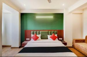 a bedroom with a bed and a green wall at OYO Admi Suites in New Delhi