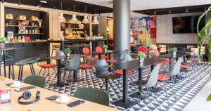 a restaurant with tables and chairs on a checkered floor at Ibis Barcelona Aeropuerto Viladecans in Viladecáns