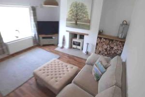 a living room with a couch and a fireplace at Pretty Neyland Cottage central to all attractions in Milford Haven