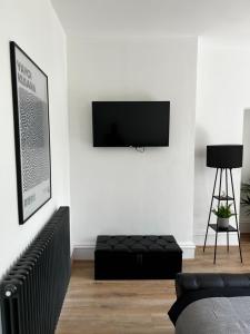 sala de estar con TV en una pared blanca en No.1 Beechcroft en Liverpool