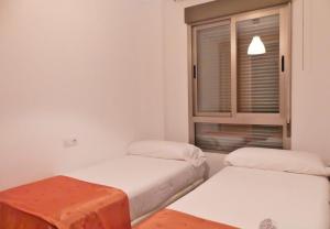Cette chambre comprend 2 lits et une fenêtre. dans l'établissement Atico Carrer de la Mar, à El Campello