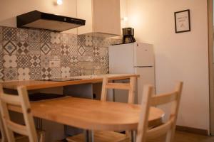 eine Küche mit einem Holztisch und einem Kühlschrank in der Unterkunft Chez Moltess in Seignosse