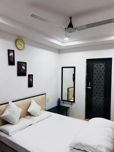sypialnia z łóżkiem i zegarem na ścianie w obiekcie OYO National Inn w mieście Jamshedpur