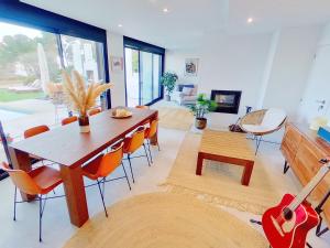 sala de estar con mesa y guitarra en Premium Habitat 3 Hermanas, en Sant Andreu de Llavaneres