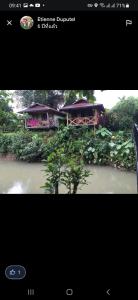a screenshot of a picture of a house on a river at Maylyn Guesthouse in Vang Vieng