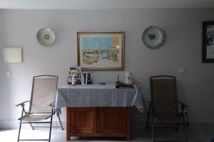 Zimmer mit 2 Stühlen, einem Tisch und einem Bild in der Unterkunft Lemon Tree Cottage at Terrus Winery in Barrô