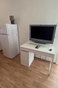 escritorio blanco con TV y nevera en B&B Treviso, en Treviso