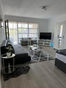 a living room with a couch and a tv at Idyllisches Apartment - Moderne 1ZKB Balkon 2 Personen Self-Check-in 24h in Bad Nauheim
