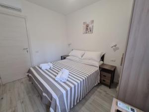 een kleine slaapkamer met een bed met handdoeken erop bij Civico 14 Apartment 01 in Monserrato