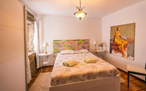 a bedroom with a bed and a painting on the wall at Leiras de Candoz Douro Valley in Marco de Canaveses +25 photos