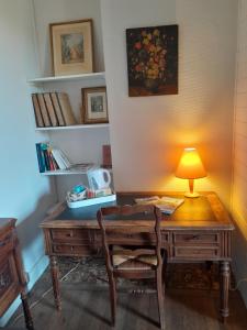 un ufficio con una scrivania e una lampada sopra di Chambres d'hôtes L'Oustal a Oloron-Sainte-Marie
