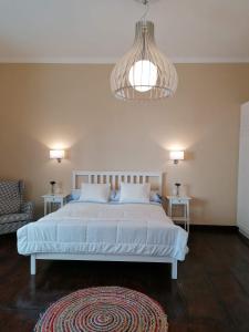a bedroom with a large bed and a chandelier at Casa Mendoza in Santa Cruz de la Palma