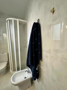La salle de bains est pourvue de toilettes et d'une serviette bleue sur le mur. dans l'établissement PISO EN PLENO CENTRO DE MIÑO II, à Miño