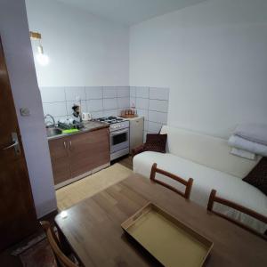 a small kitchen with a couch and a table in a room at Hostel Lena-Mostar in Mostar