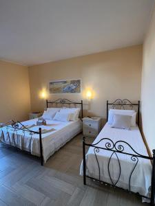 twee bedden in een slaapkamer met twee lampen aan bij B&B Zio Cici in Minervino di Lecce