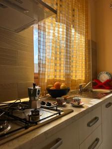 a kitchen with a stove and a bowl of fruit at B&B Zio Cici in Minervino di Lecce