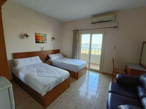 a hotel room with two beds and a couch at بيت الشباب الاسماعيلية - Ismailia Youth Hostel in Ismailia