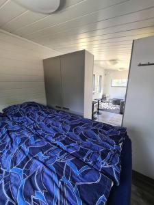 Schlafzimmer mit blauer Decke auf einem Bett in der Unterkunft Ryysyranta 