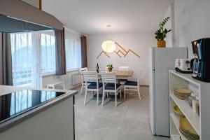 Il comprend une cuisine et une salle à manger avec une table et un réfrigérateur. dans l'établissement Apartma na hribu, à Mojstrana