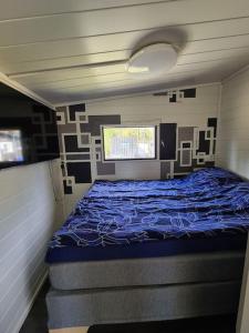 ein Schlafzimmer mit einem blauen Bett in einem Zimmer in der Unterkunft Ryysyranta 