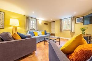 a living room with two couches and a table at Garden Cottage in Ringstead