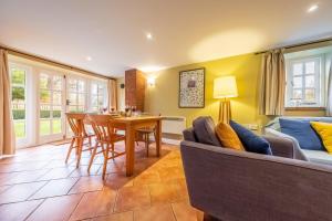 a living room with a couch and a table at Garden Cottage in Ringstead